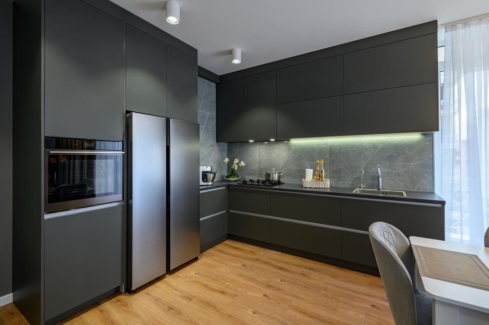 Modern farmhouse style kitchen with grey laminate cabinets and stainless steel appliances.