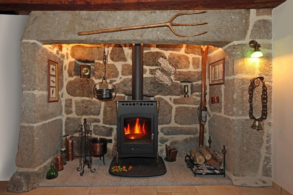 A fireplace with a stove in the middle of it