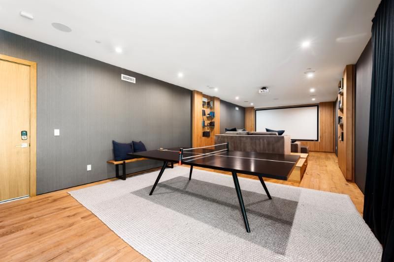 A living room with a table and a projector screen.