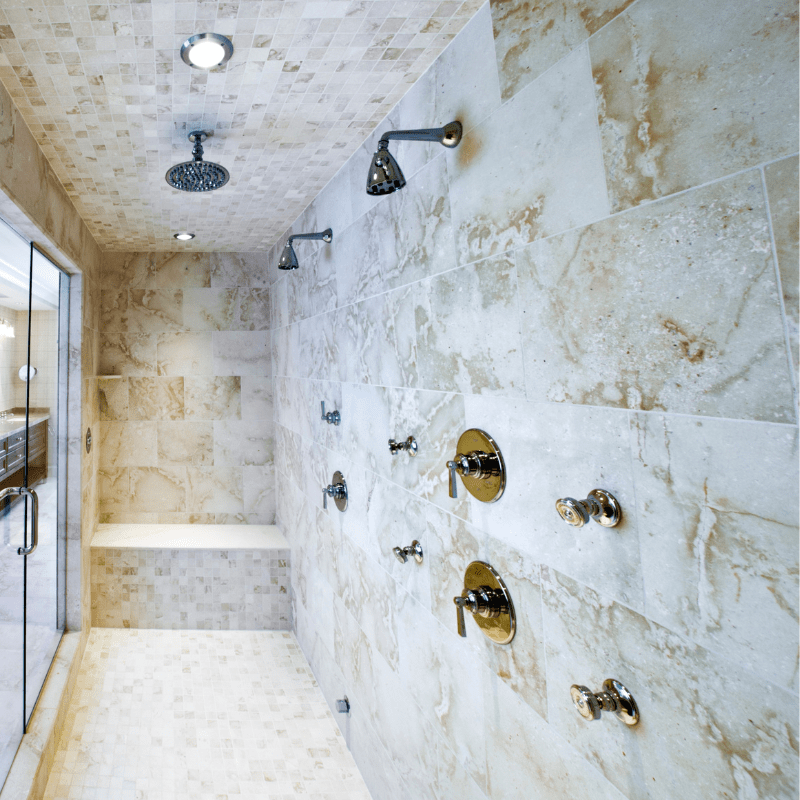 A shower with a lot of shower heads on the wall