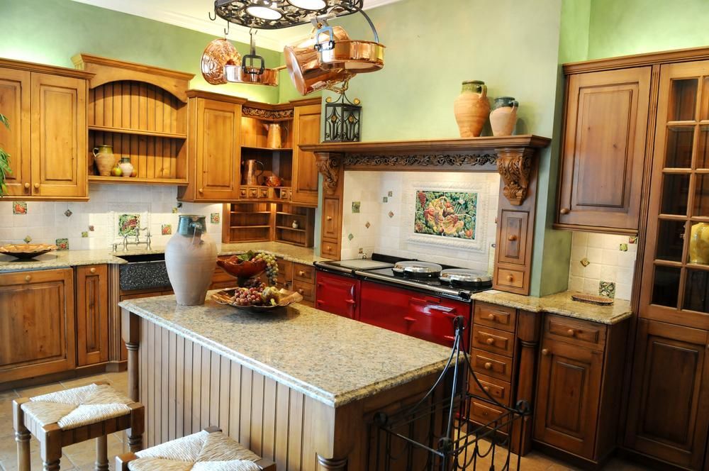 Country vintage farmhouse kitchen remodel with solid wood cabinets and natural stone slab countertops and brightly colored appliances.