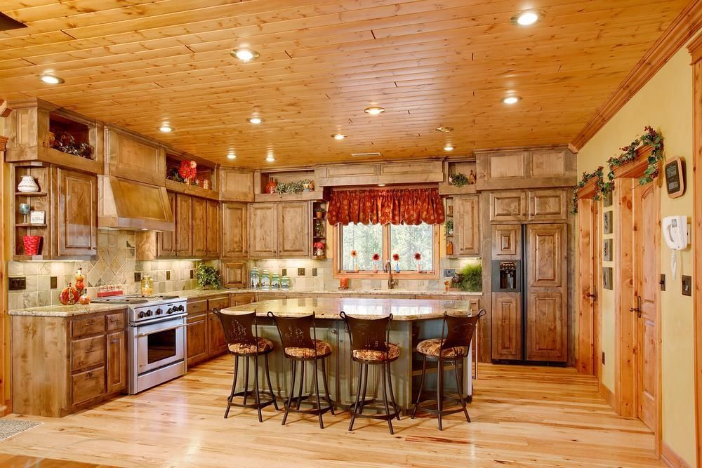 Warm and cozy farmhouse style kitchen with wood sliplap ceilings, wood floors and natural stone countertops.