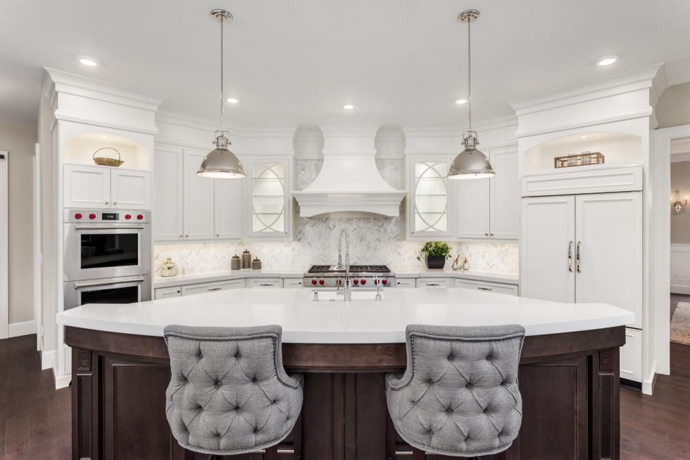 A kitchen with a large island and two chairs.