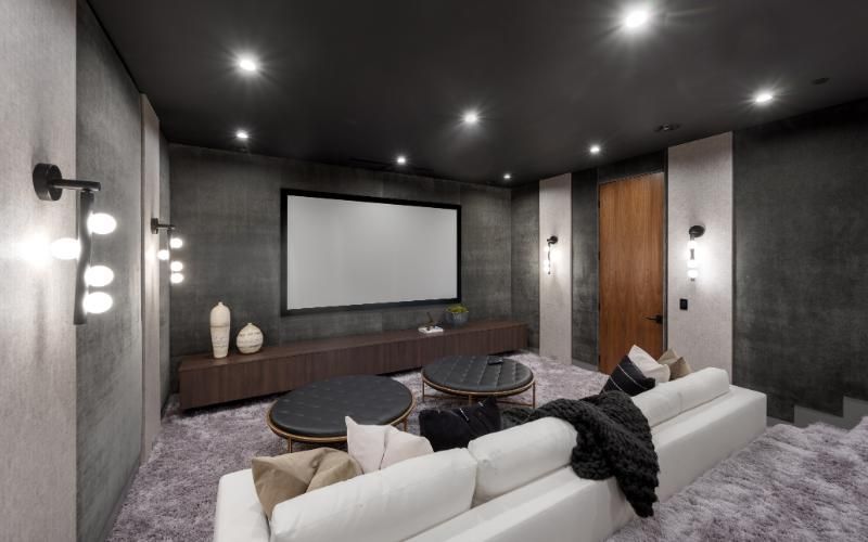 A living room with a couch and a projector screen.