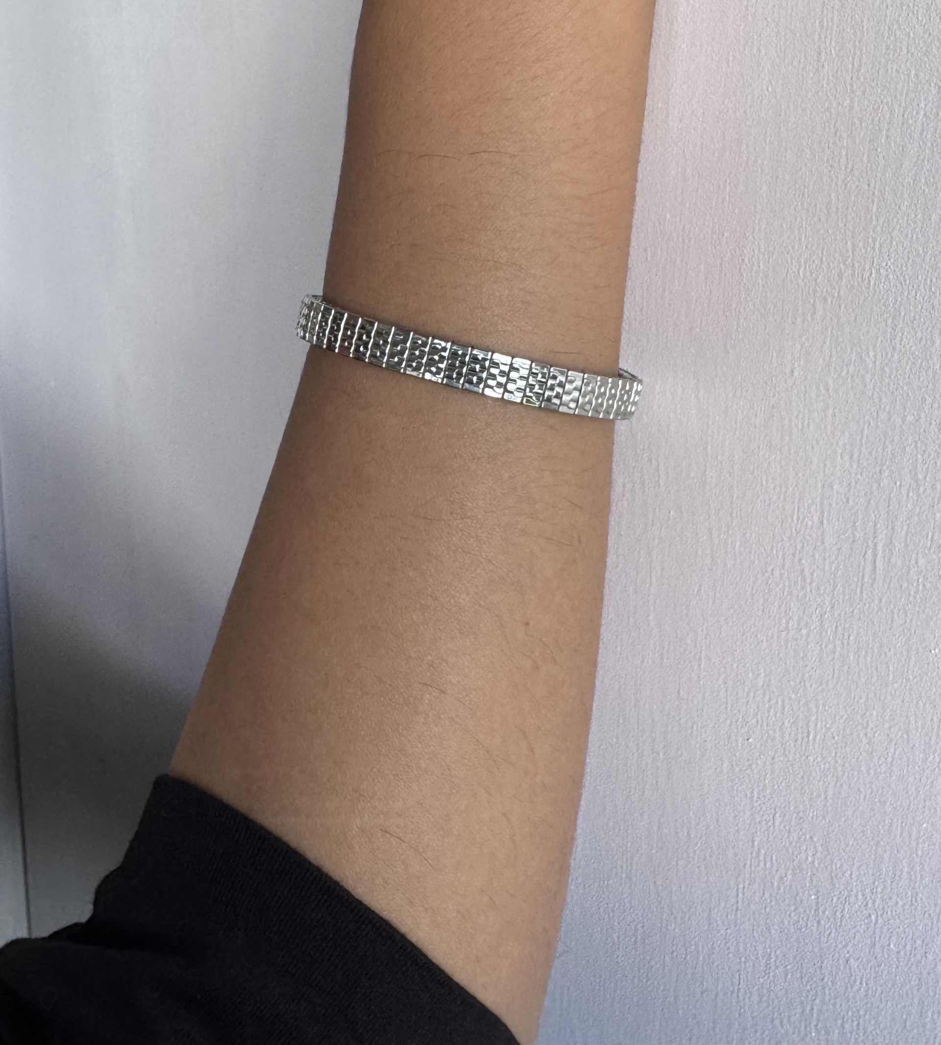 Una persona que lleva una pulsera de plata en la muñeca