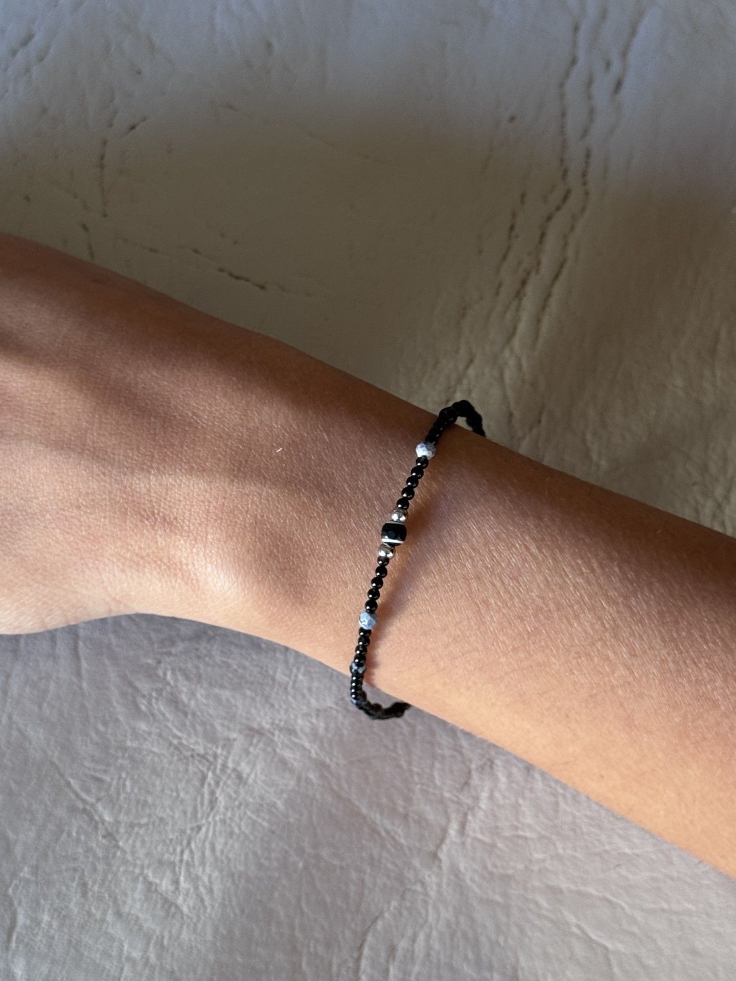 Una persona que lleva una pulsera negra en la muñeca