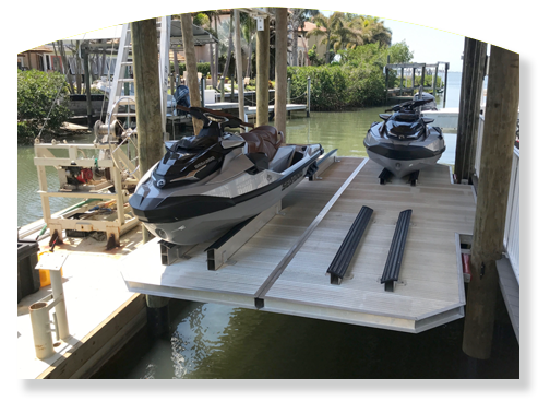 Two jet skis on a boat lift at a dock.