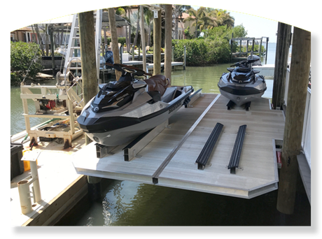 Two jet skis on a boat lift at a dock.