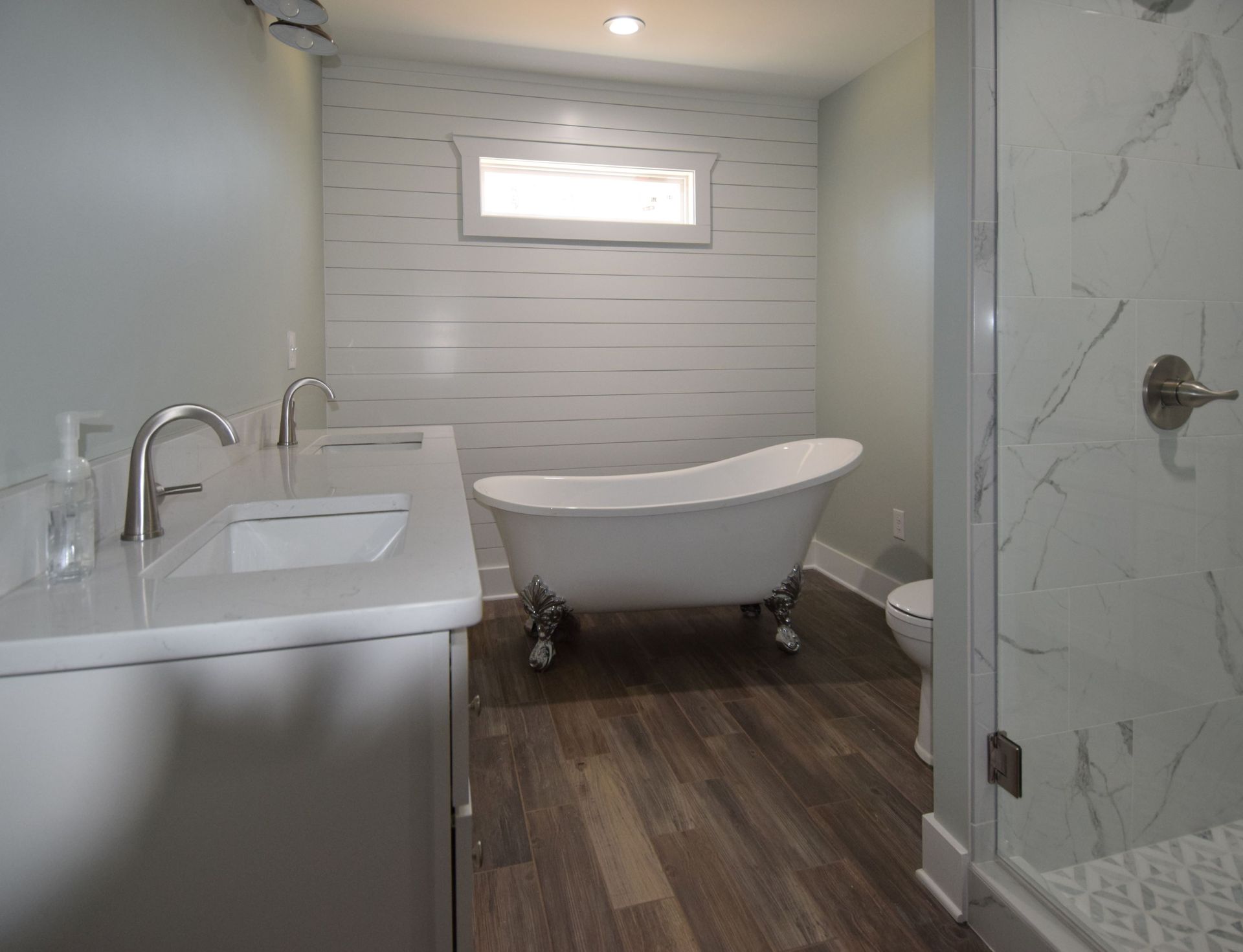 A bathroom with a tub , sink , toilet and shower.