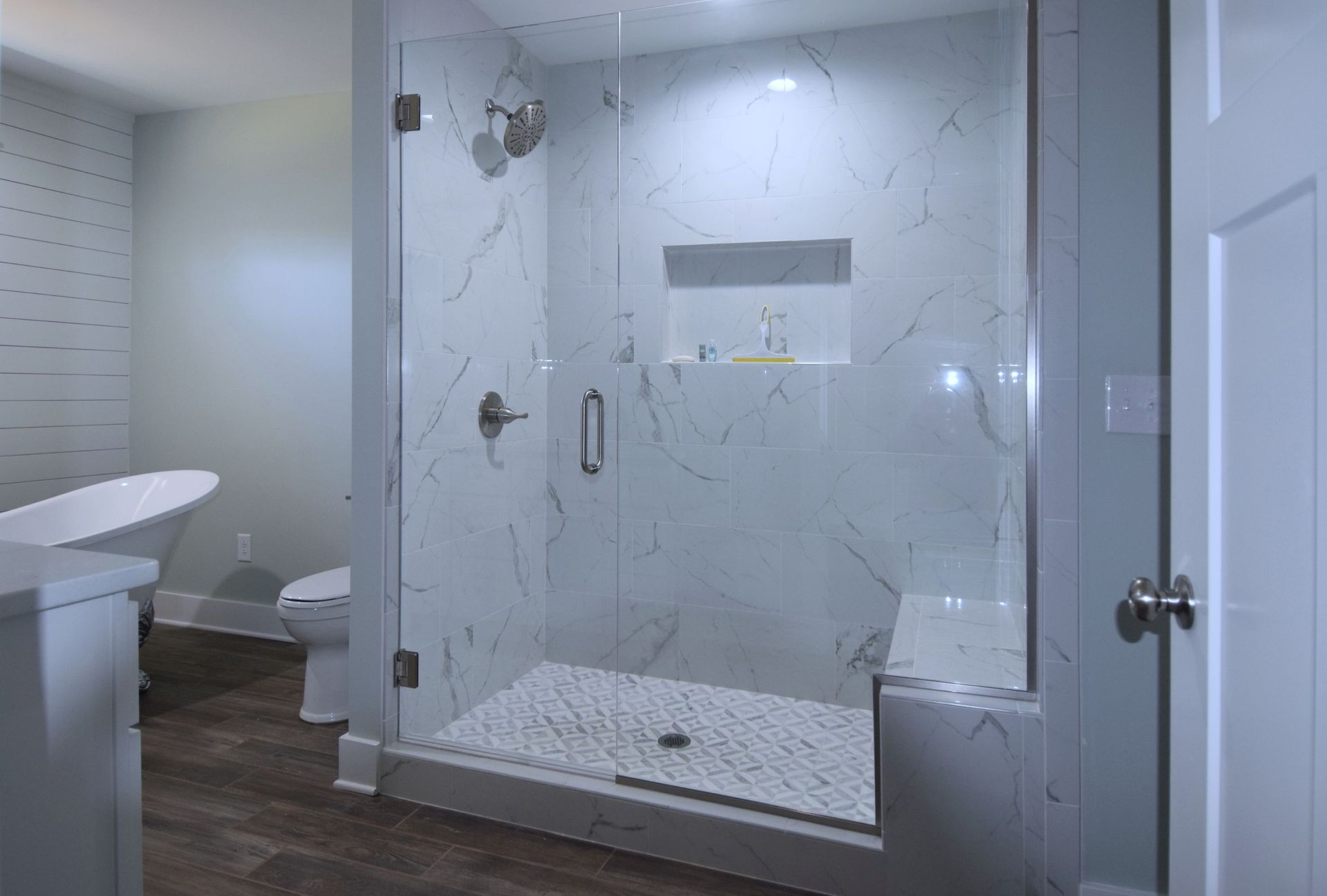 A bathroom with a walk in shower and a bathtub.