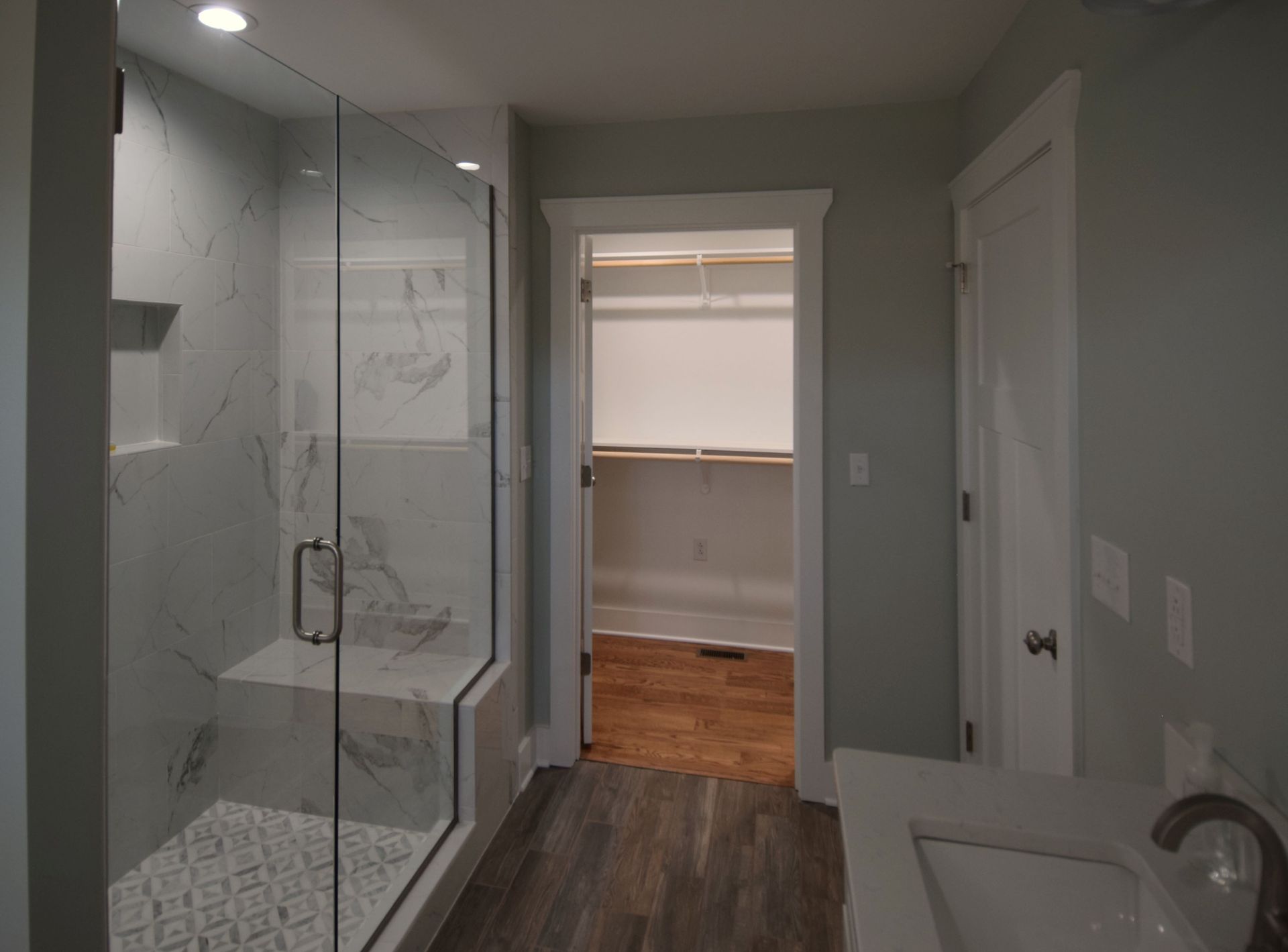 A bathroom with a walk in closet and a walk in shower.