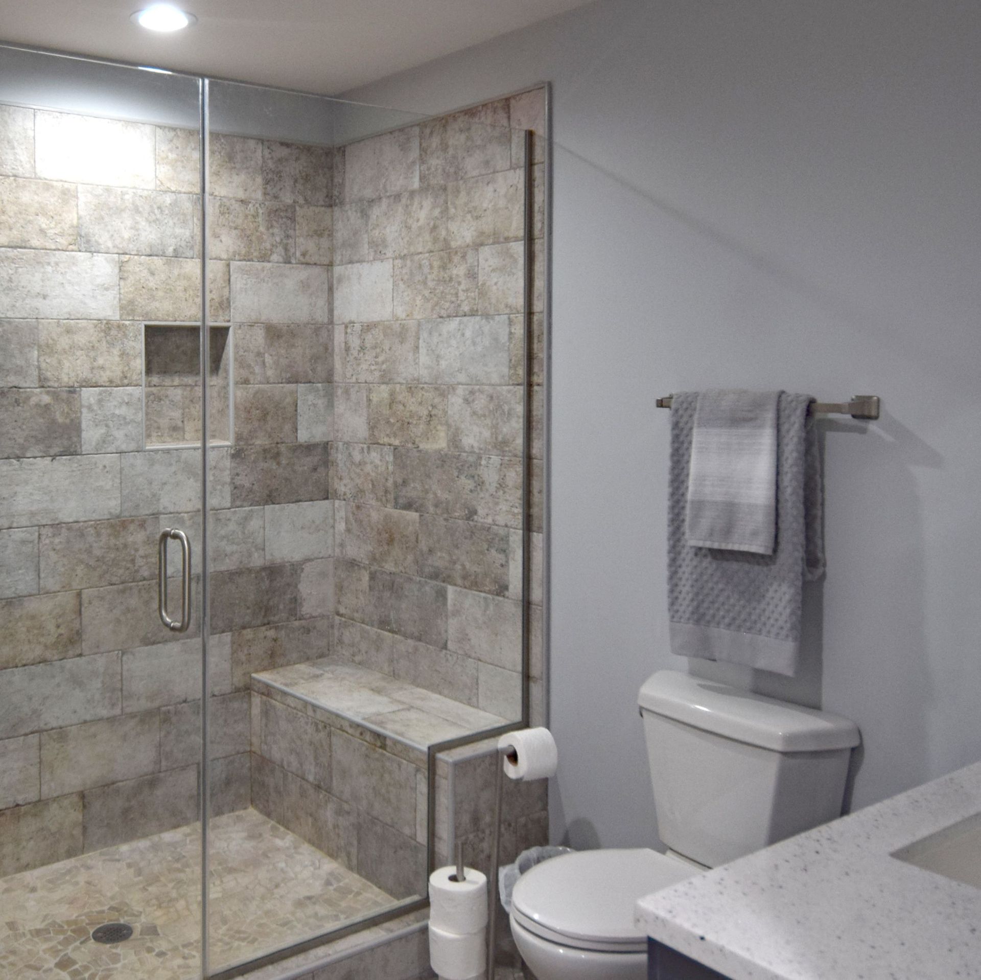 A bathroom with a toilet a sink and a walk in shower