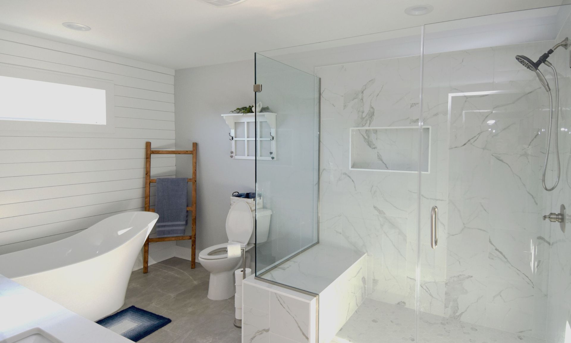 A bathroom with a tub , toilet , shower and walk in shower.