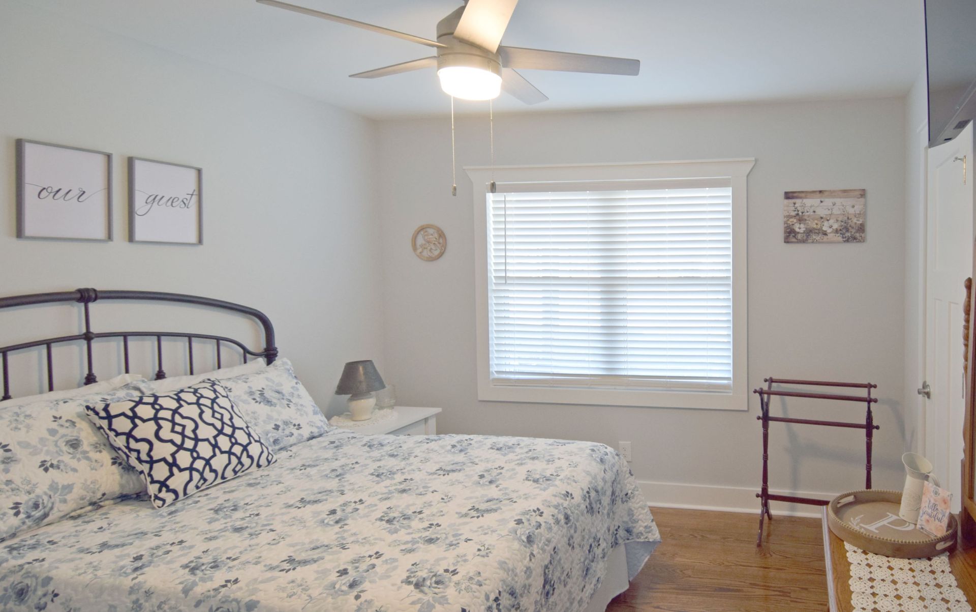 A bedroom with a bed , ceiling fan , and window.