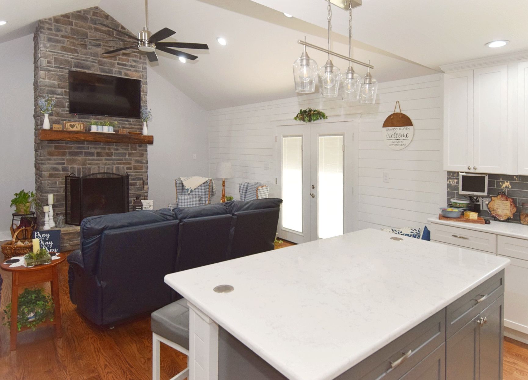 A kitchen with a large island in the middle of it and a living room with a fireplace.