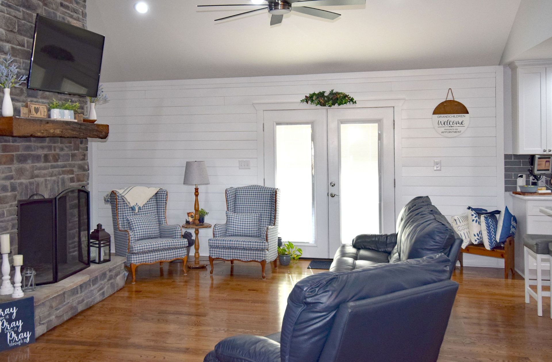 A living room with a couch , chairs , fireplace and television.