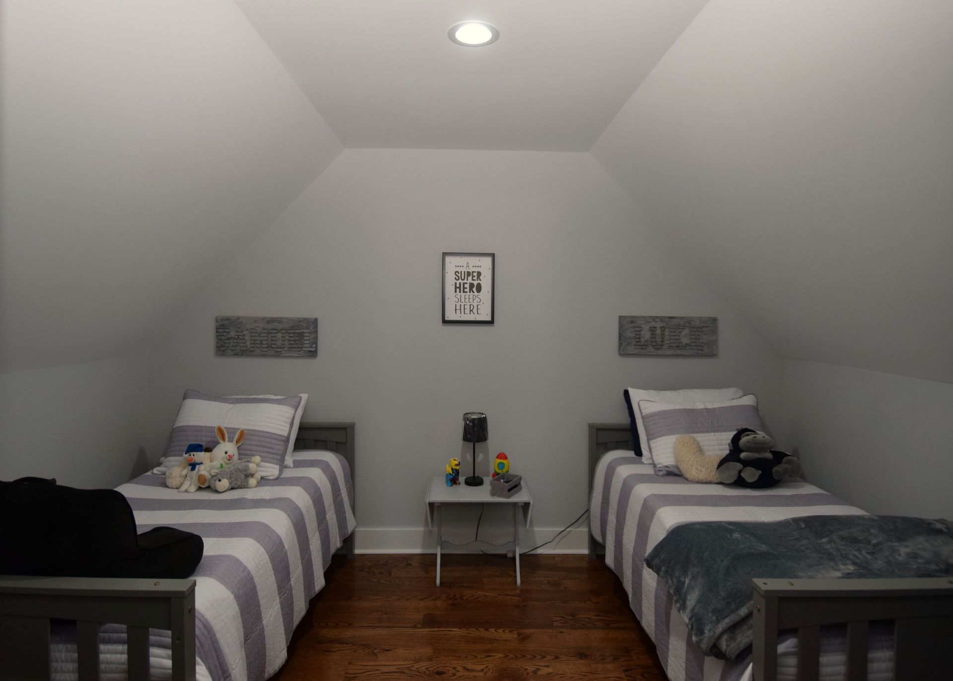 A bedroom with two twin beds and a nightstand.