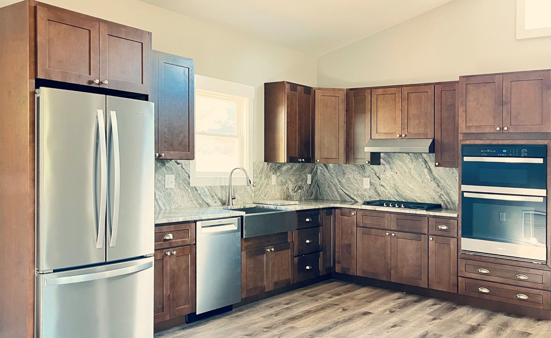 A kitchen with stainless steel appliances and wooden cabinets.