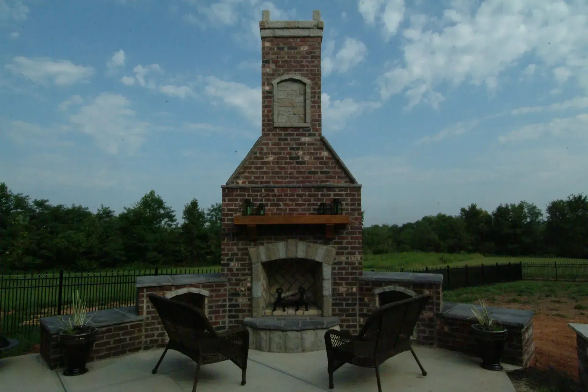 Two chairs are sitting in front of a large brick fireplace.