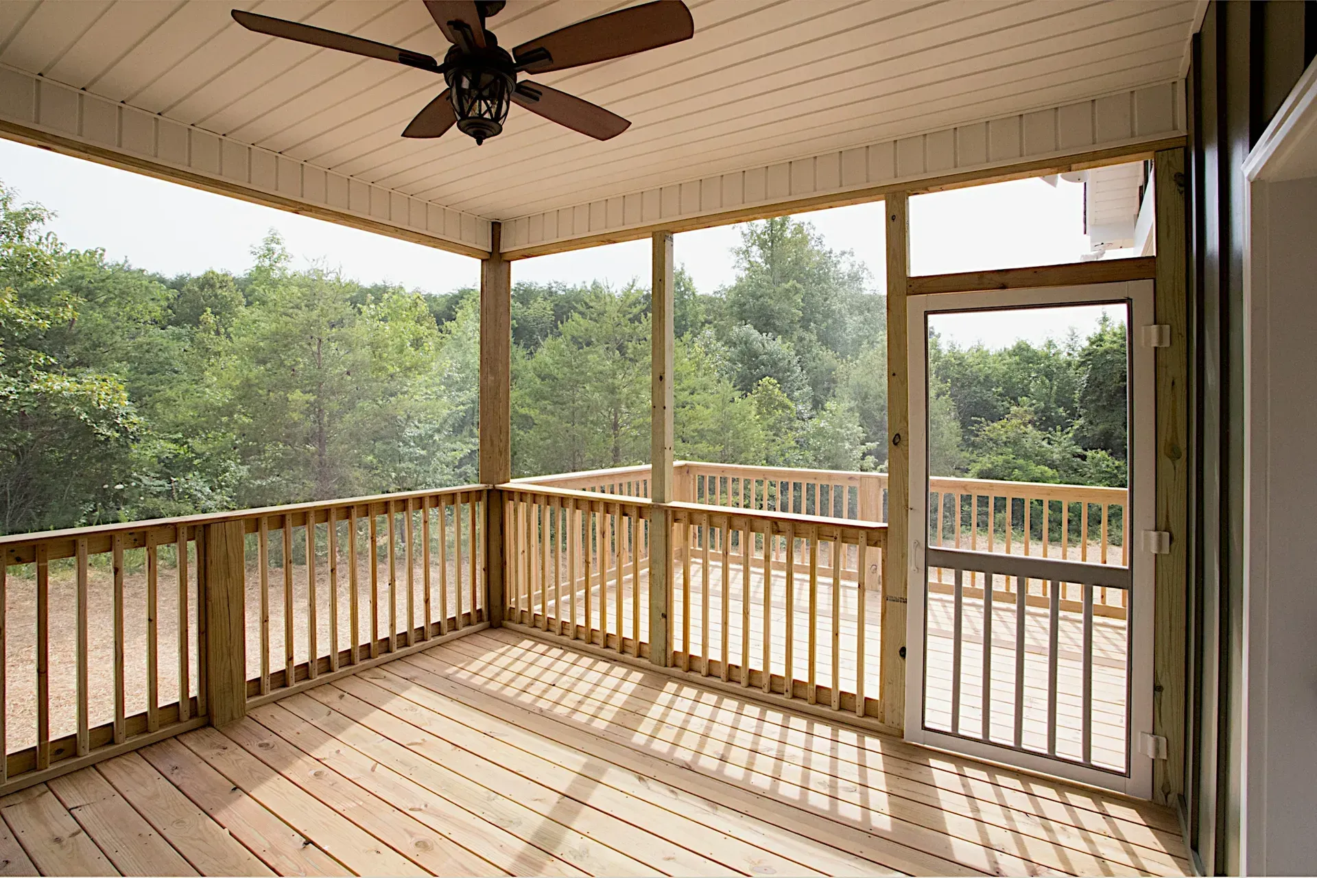 A screened in porch with a ceiling fan