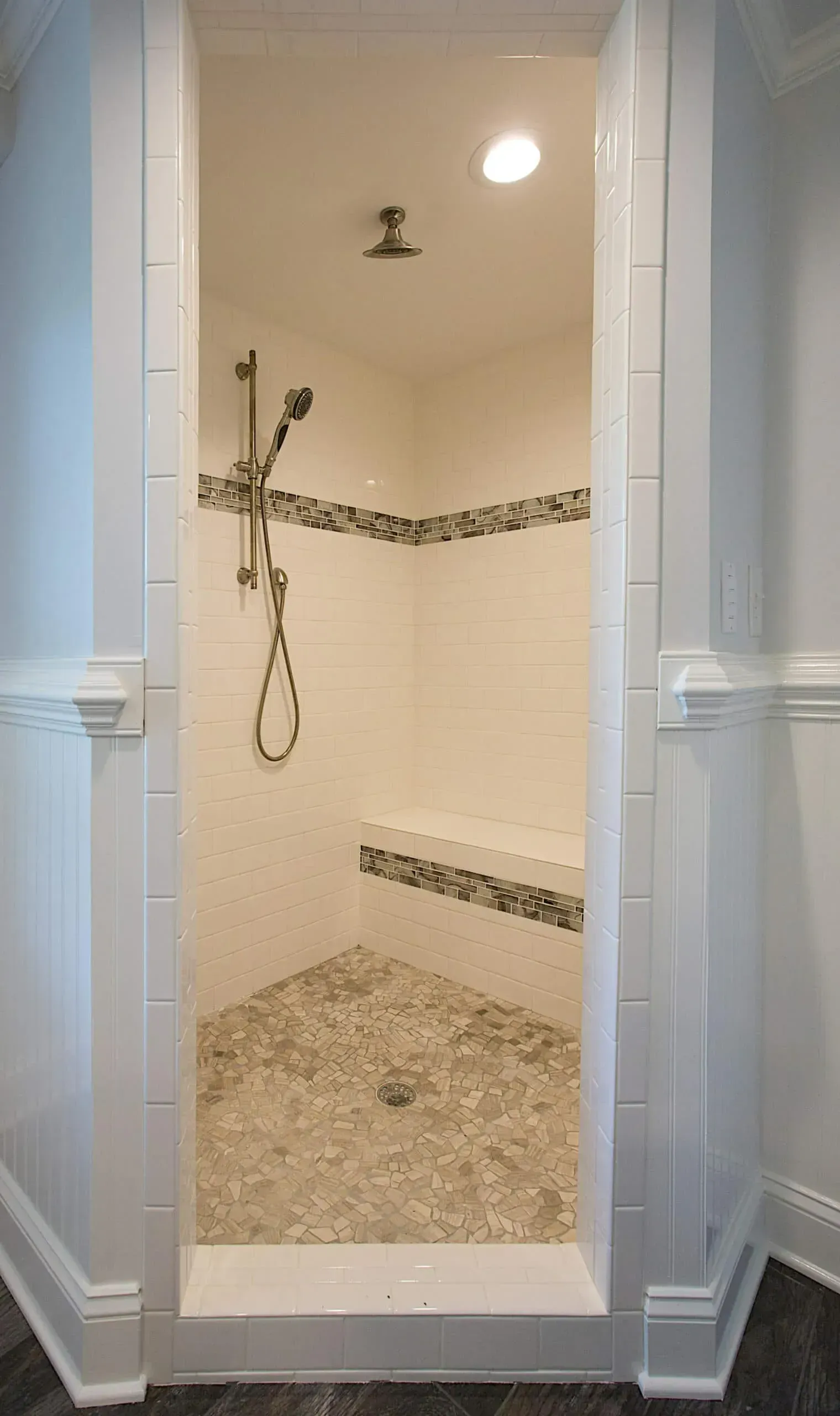 A bathroom with a walk in shower and a shower head.