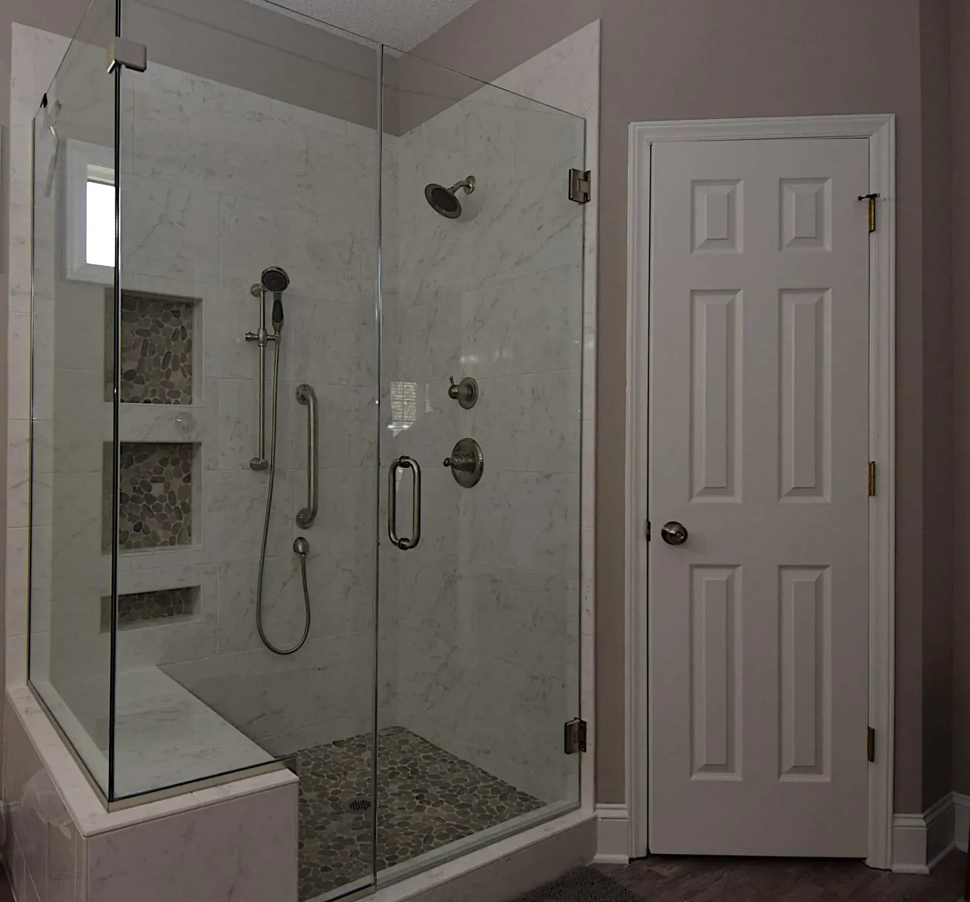 A bathroom with a walk in shower and a door