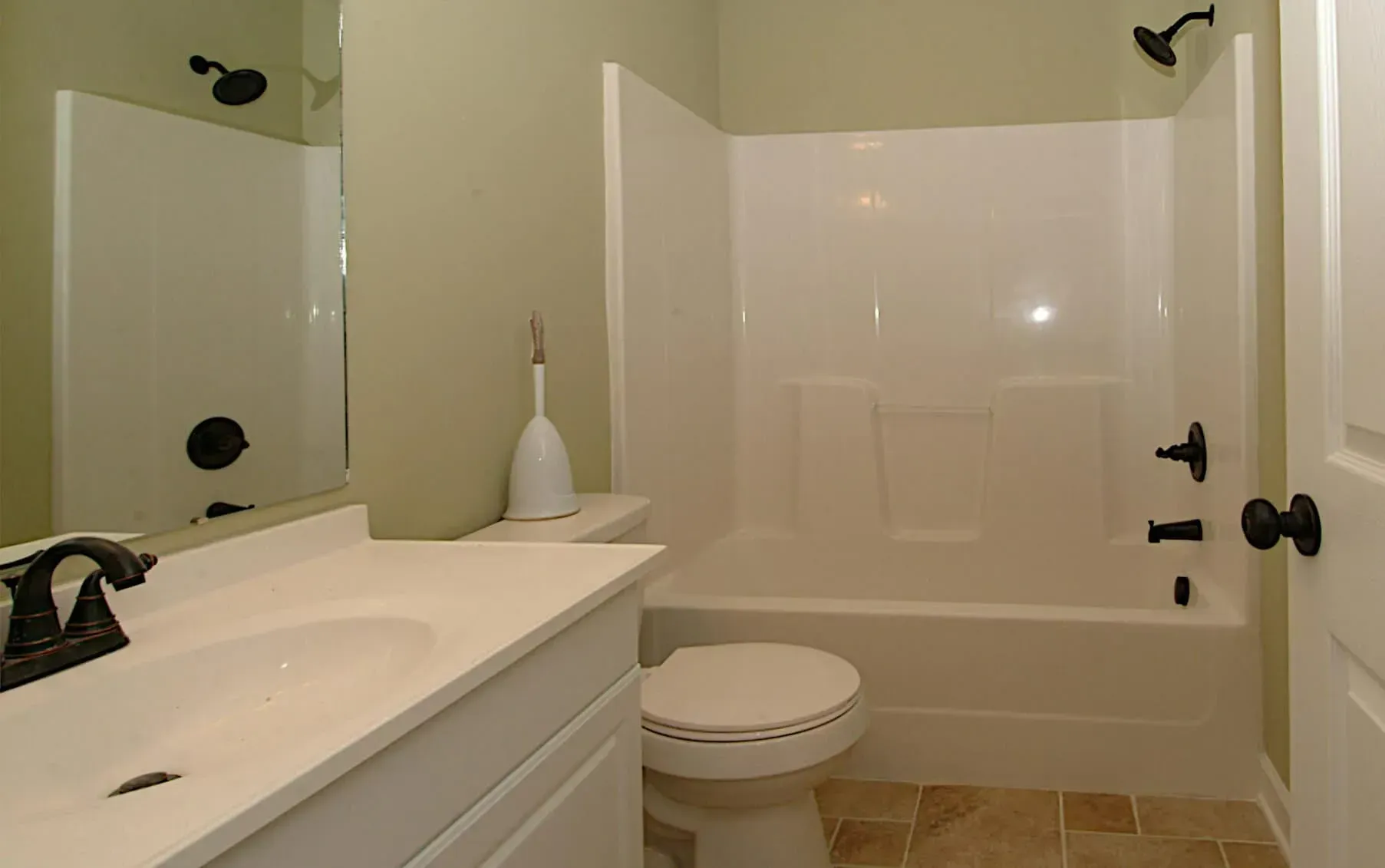 A bathroom with a toilet , sink and shower.