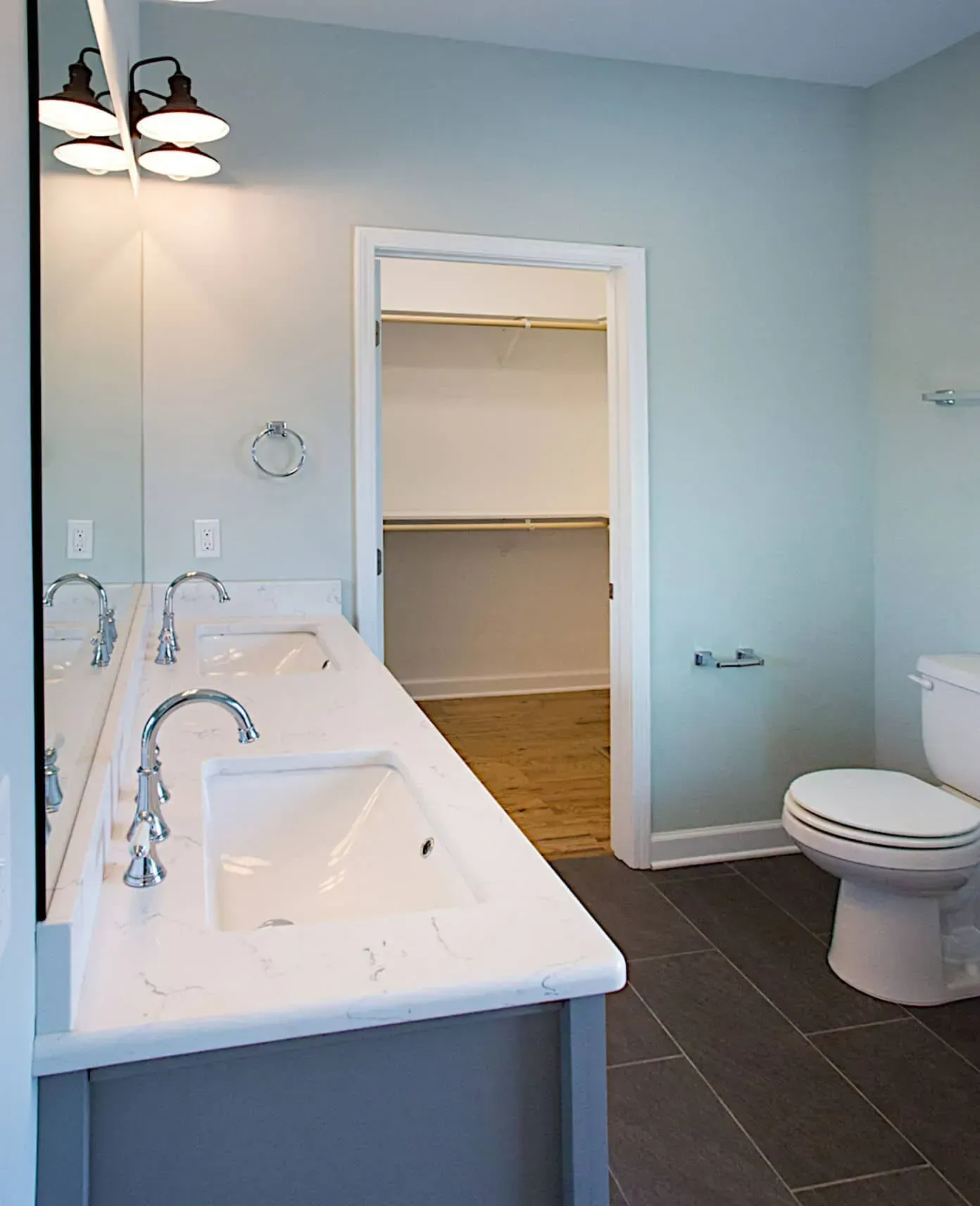 A bathroom with two sinks and a toilet