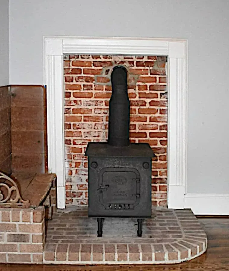 A brick fireplace with a wood stove in it