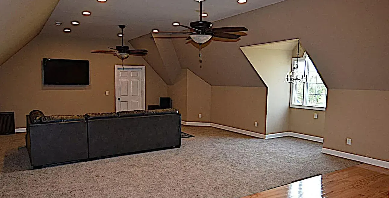 A living room with a ceiling fan and a flat screen tv