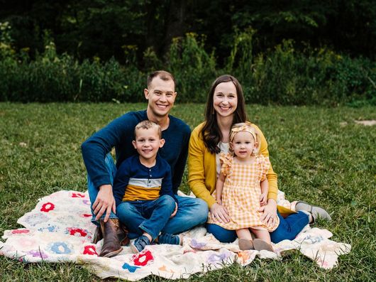 A family is posing for a picture with two children.