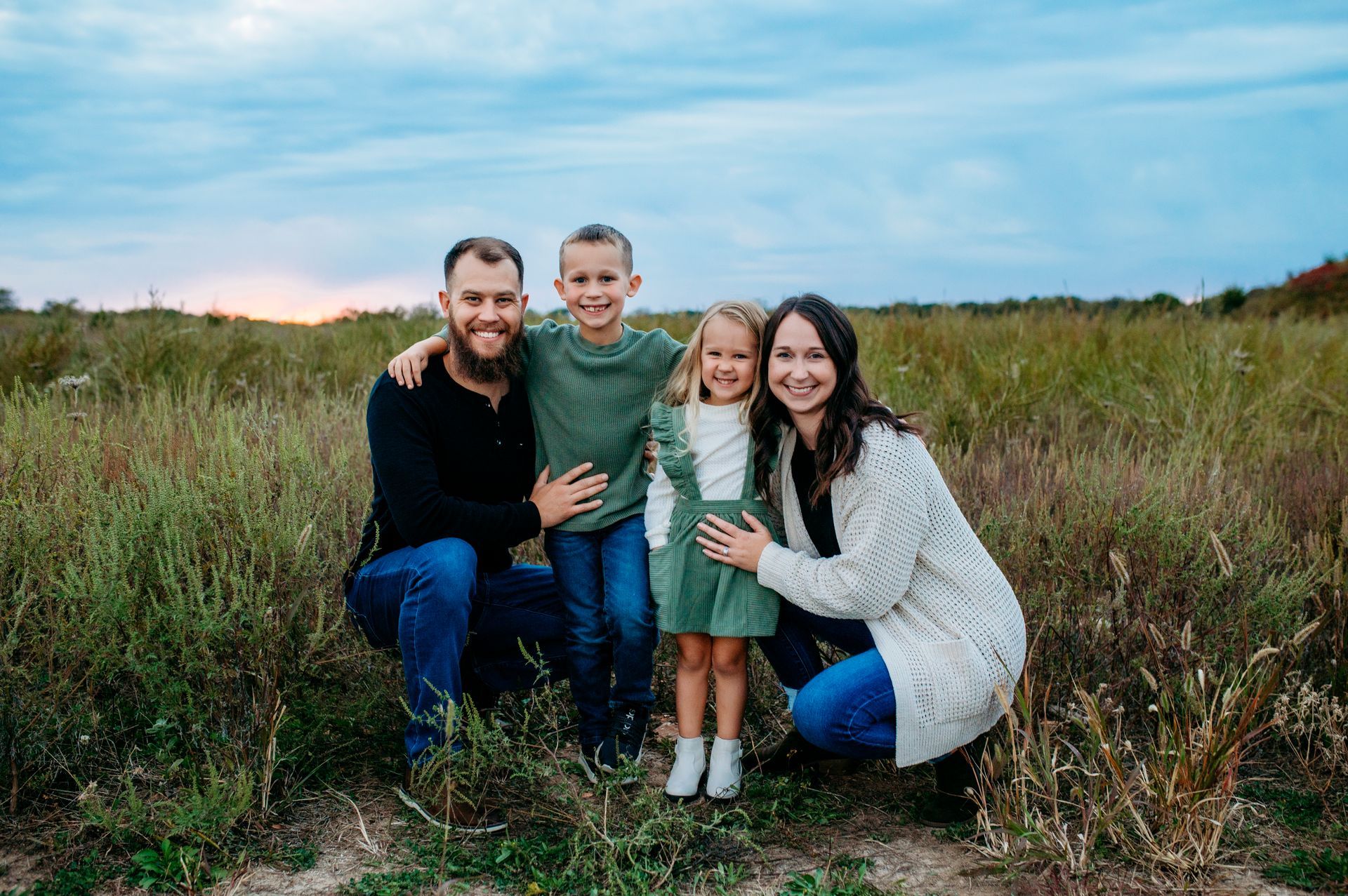 A family is posing for a picture with two children.