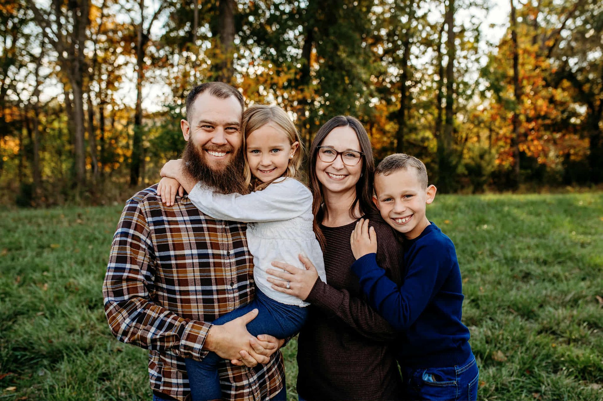 A family is posing for a picture with two children.