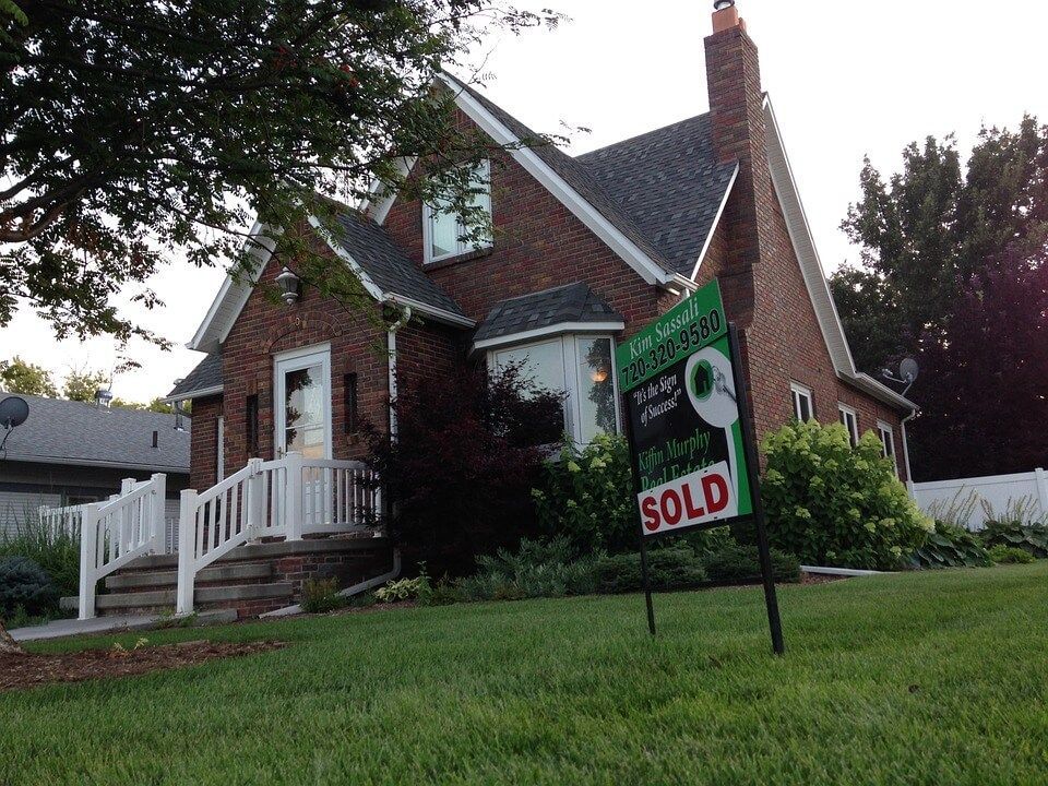 A house with a sold sign in front of it