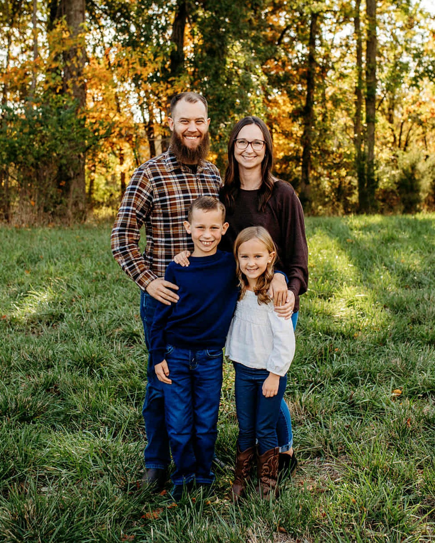 A family is posing for a picture with two children.