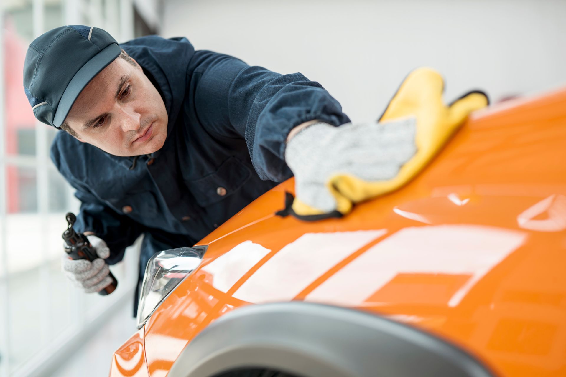 A male car mechanic is polishing a car after a car ceramic coating.