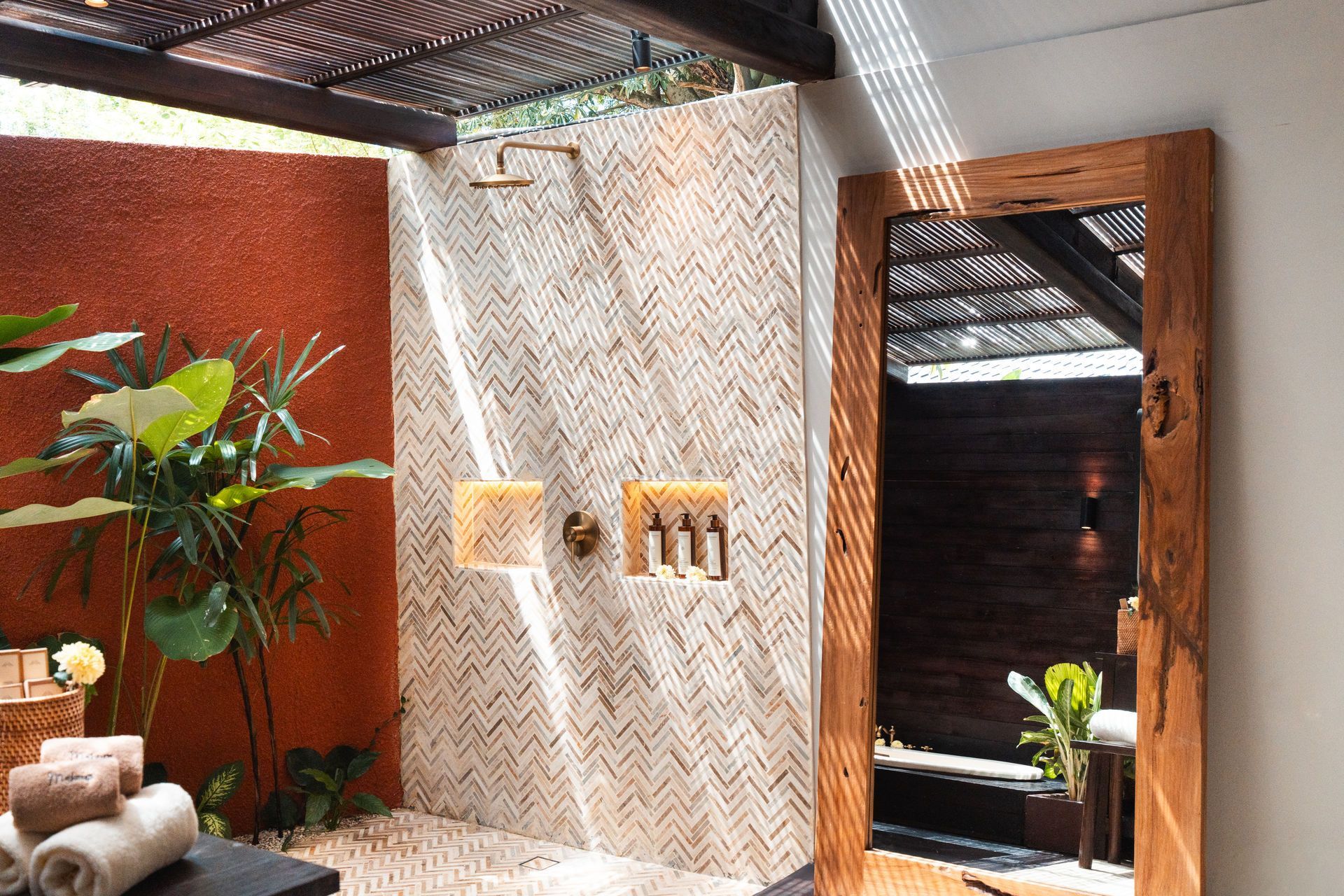 Modern spa interior with textured walls, potted plants, woven ceiling, and wooden doorway