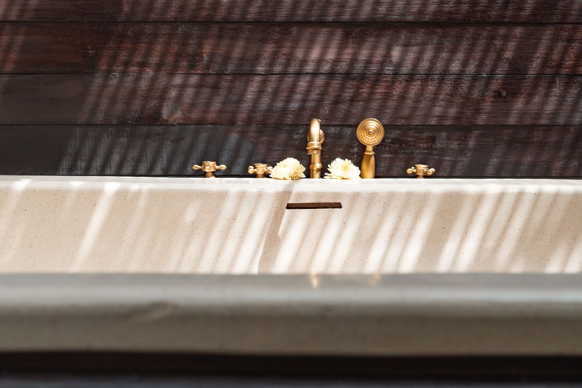 Small gold-colored figurines on a ledge against a dark patterned background