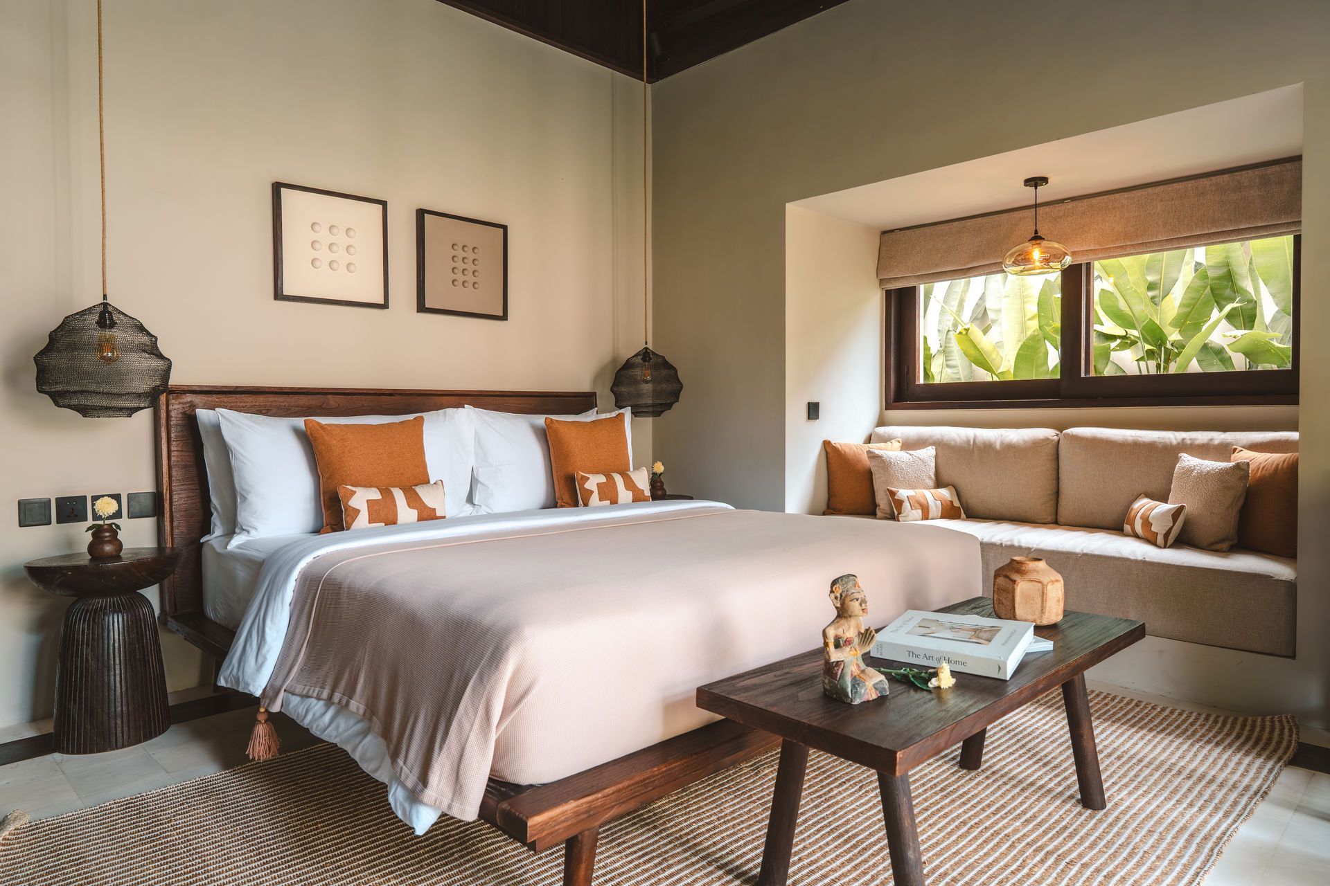 Stylish bedroom with a bed, bench, and window seat in warm neutral tones
