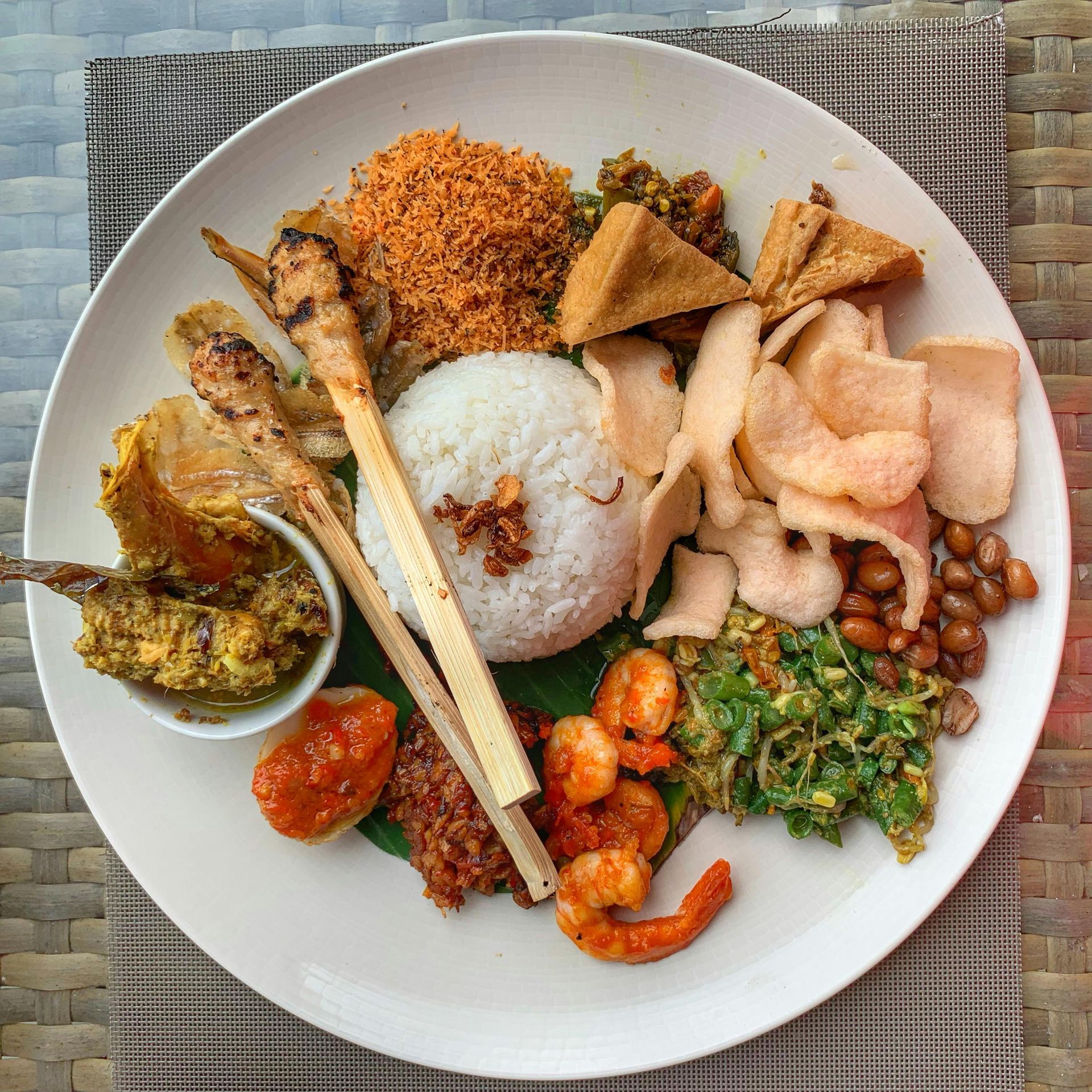Assorted Ethiopian dishes on a white plate: rice, stews, vegetables, bread, and fried sides.