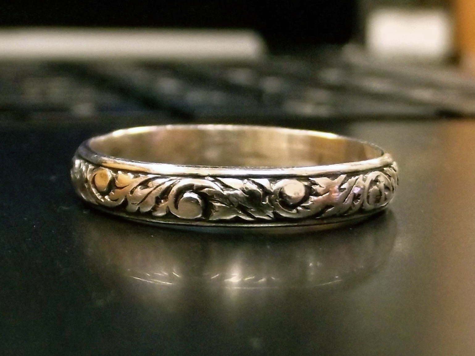 Silver ring with ornate floral design.