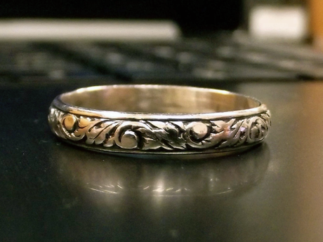 Silver ring with ornate floral design.