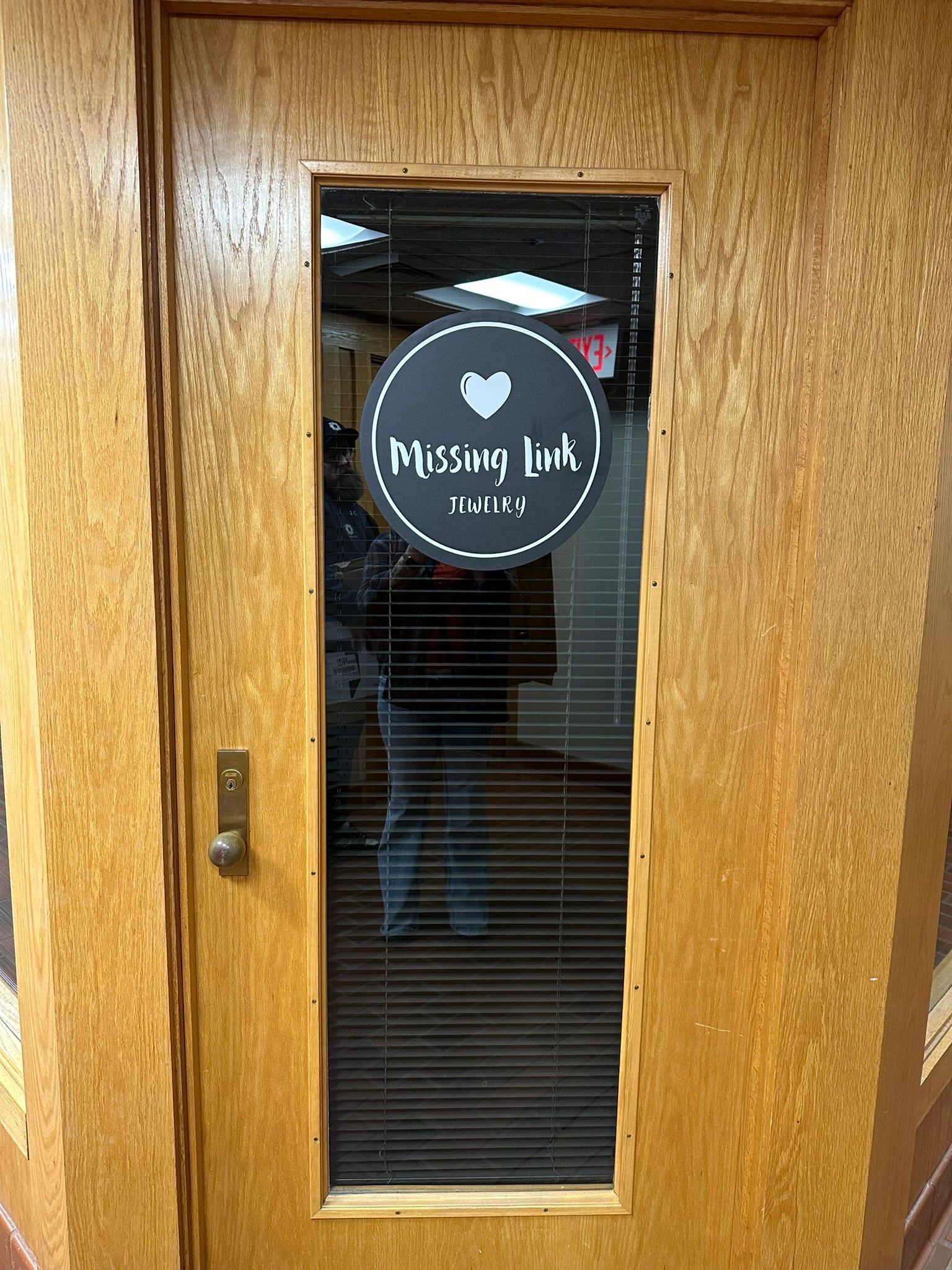 Wooden door with a window displaying a circular sign that reads 