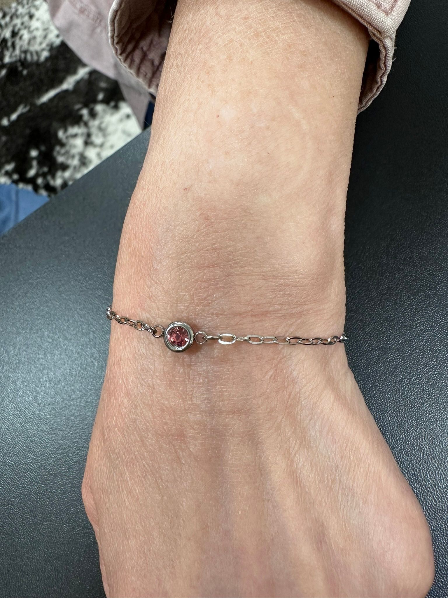Bracelet with pink center stone on a wrist.