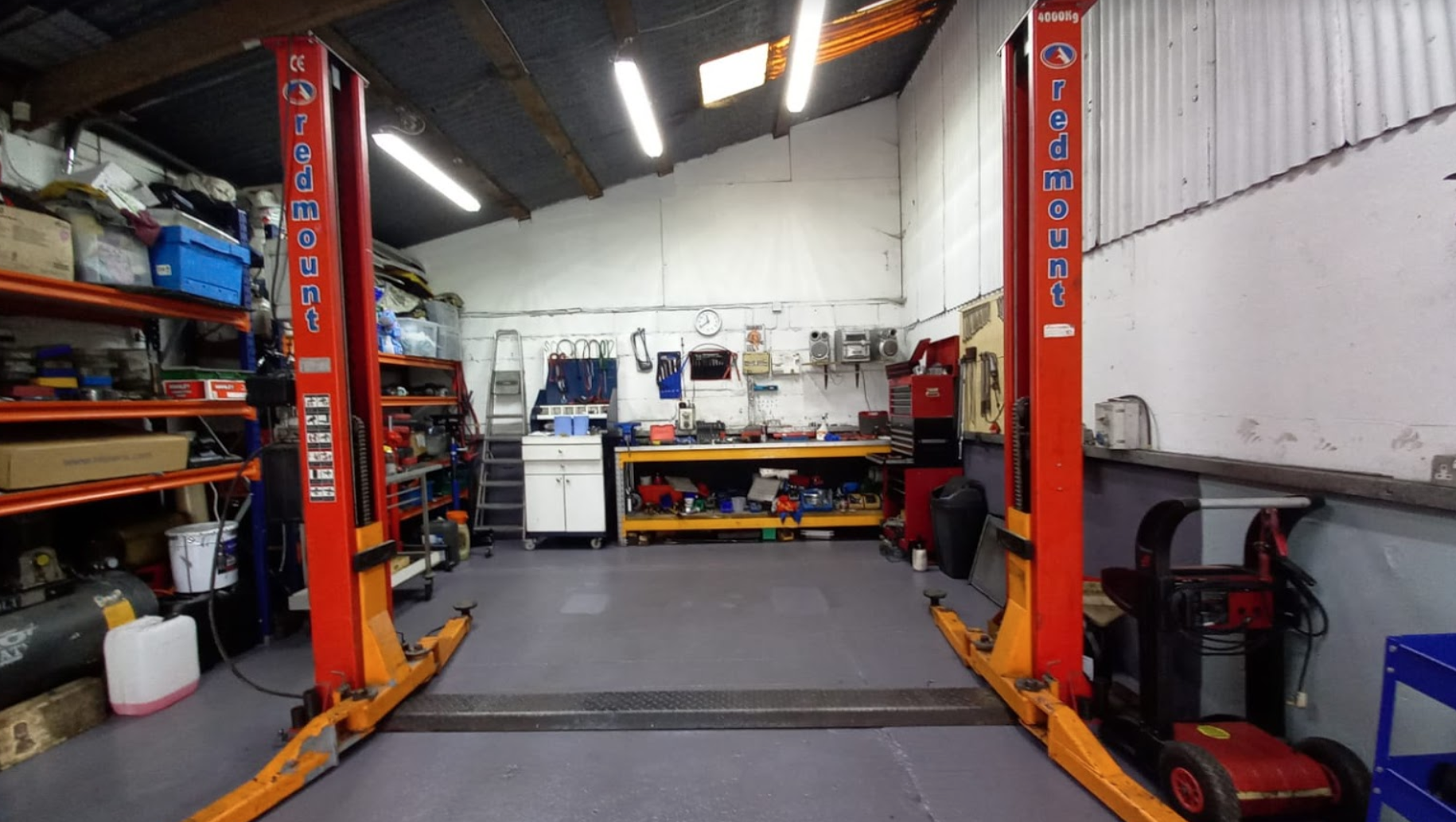 A garage with two hydraulic lifts in it.