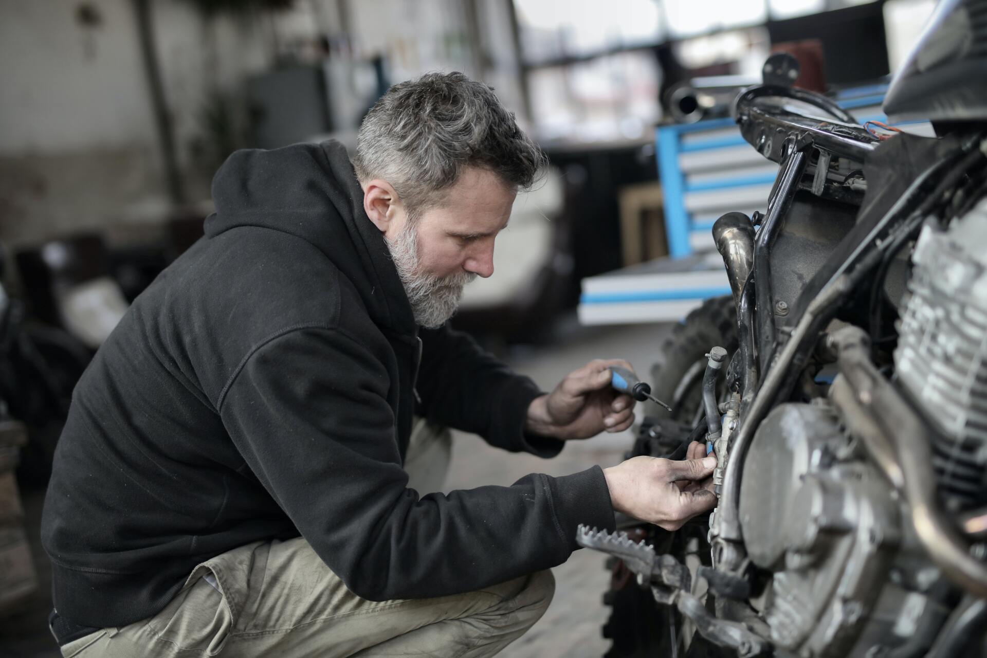 A man is working on a motorcycle in a garage.