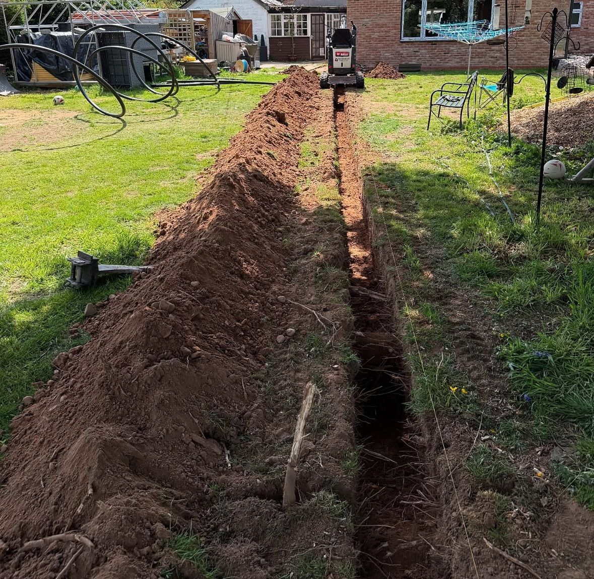 A large pile of dirt is sitting in the middle of a lush green field.