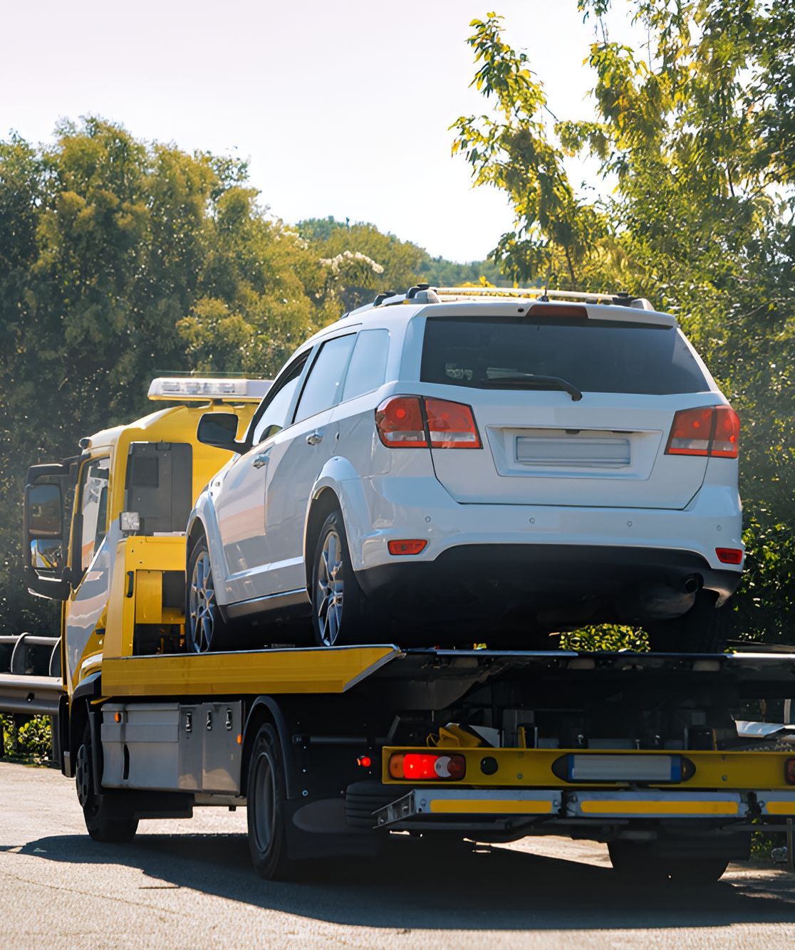 A White Suv Is Being Towed By A Yellow Tow Truck — SteelBar Restoration In Yarraman, QLD