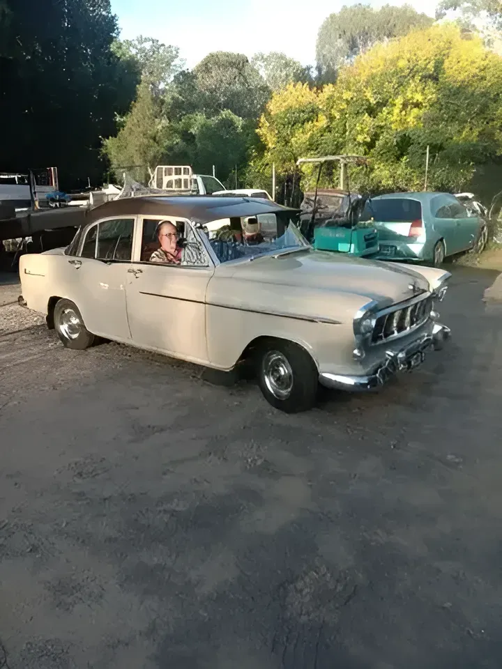 A Man Is Driving An Old Car In A Parking Lot — SteelBar Restoration In Yarraman, QLD