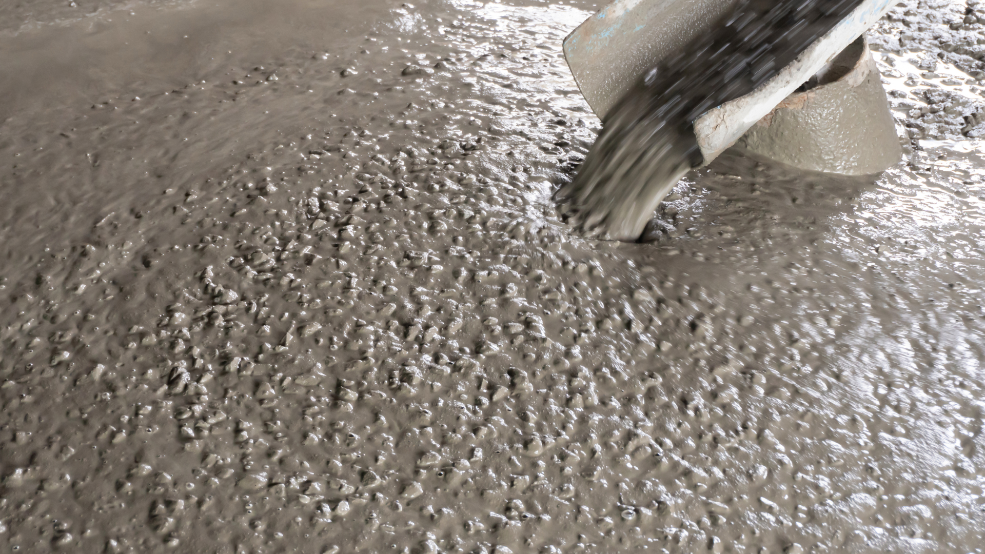 A large concrete structure is being built in a parking lot.